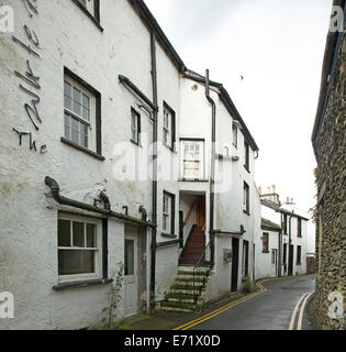 Schmale Straße schlängelt sich durch weiß lackierte Steinbauten in alten englischen Dorf in der Nähe von Windemere, Lake District, Cumbria, England Stockfoto