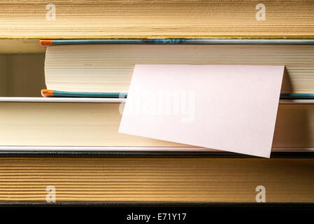 Nahaufnahme von einem Stapel Bücher für Studien mit einem Post-It-Papier-Schuldbrief Stockfoto