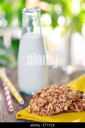 Müsli-Kekse und Milch auf Holztisch Stockfoto