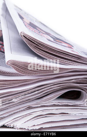 Nahaufnahme der gestapelten Zeitungen auf weißem Hintergrund. Stockfoto