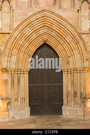 Holztür mit großen und spektakulären dekorative Scharniere umgeben von kunstvollen Steinbögen im historischen Bolton Priorat Kirche England gewölbt Stockfoto