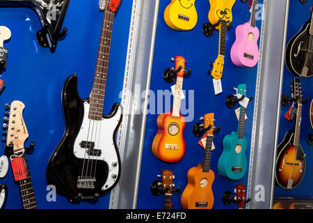 Auswahl an Gitarren und Ukulelen auf dem Display in einem Musikgeschäft, Norfolk, Großbritannien. Stockfoto