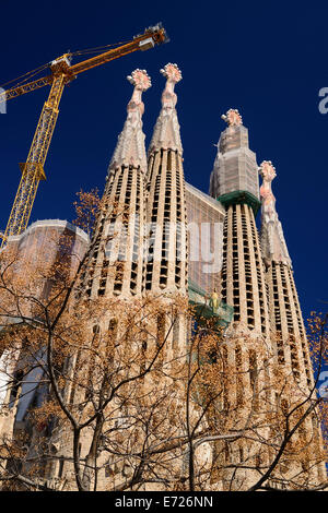 Spanien, Katalonien, Barcelona, Basilika ich Temple Expiatori De La Sagrada Familia Sagrada Familia allgemeinen Blick auf die Leidenschaft Fassade mit Kran hängenden oben genannt. Stockfoto