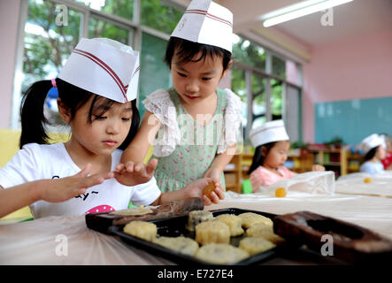 Hefei, China Anhui Provinz. 4. September 2014. Kinder benutzen Werkzeuge, Mooncakes in Hefei, Hauptstadt der ostchinesischen Provinz Anhui, 4. September 2014 machen. Das Mid-Autumn Festival, das am 8. September dieses Jahres fällt, ist ein traditionelles chinesisches fest für Familientreffen, während die Leute der Vollmond zusammen genießen und Essen Mondkuchen - kleine Runde Kuchen mit verschiedenen Füllungen. © Liu Junxi/Xinhua/Alamy Live-Nachrichten Stockfoto