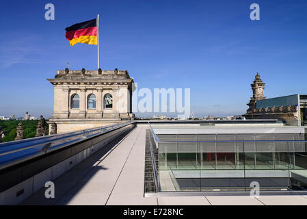 Deutschland, Berlin, deutsche Flagge flattern auf einem Eckturm des Reichstagsgebäudes von der Dachterrasse aus gesehen. Stockfoto