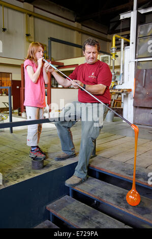 Mädchen bläst einem Garten Glas Kugel, Glaser Workshop, Glashütte Freiherr von Poschingerstraße, Frauenau, Niederbayern Stockfoto