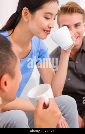 Junge Asiatin Kaffeetrinken mit ihren Freunden Stockfoto