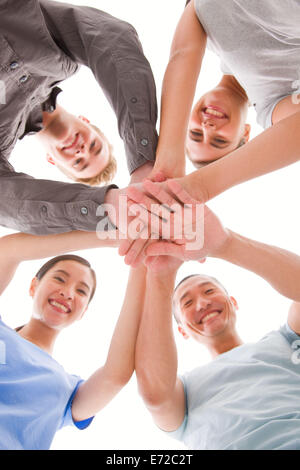 Glücklich Geschäftsleute platzieren ihre Hände oben auf einander Stockfoto