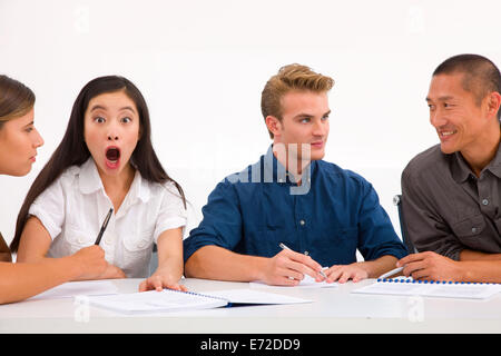 Überrascht Geschäftsfrau mit ihren Kollegen am Arbeitsplatz Stockfoto