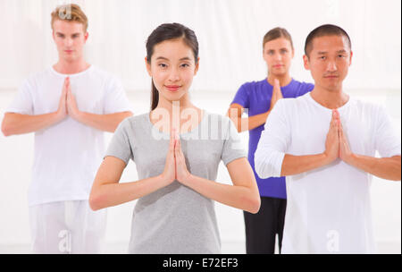 Multi-ethnische Gruppe von fröhlichen Menschen, die Yoga machen Stockfoto