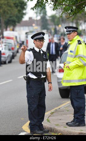 Edmonton, London, UK. 4. September 2014. Szene des Verbrechens Offiziere und Polizei auf der Straße in Edmonton, wo eine Frau gefunden wurde, enthauptet in einem Garten hinter dem Haus. Bildnachweis: Matthew Chattle/Alamy Live-Nachrichten Stockfoto