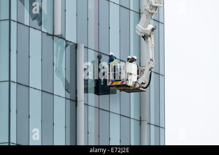 Wartungspersonal in eine Access-Plattform Wiege im Beetham Tower building, Manchester, England, UK. Stockfoto