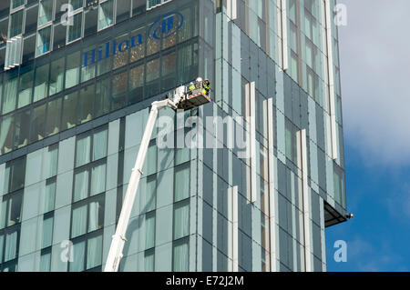 Wartungspersonal in eine Access-Plattform Wiege im Beetham Tower building, Manchester, England, UK. Stockfoto