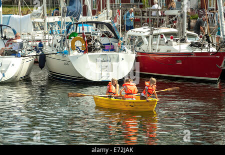 Kinder in einem Rudern Boot in den Hafen Åstol, eine Insel in den schwedischen Schären, Bohuslän, Iän Västra Götaland, Schweden. Stockfoto