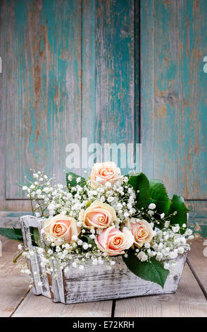 Schöne rosa Rosen und Schleierkraut Paniculata (Baby-Atem Blumen) in Holzkiste. Hochzeit-Dekor-Idee Stockfoto