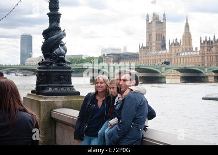 Eine Familie Besuch in London mit ihrem Foto mit den Houses of Parliament im Hintergrund, London, UK Stockfoto