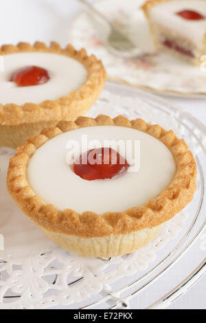 Cherry Bakewell tart Ein frangipane Gebäck Mandeln Puderzucker und eine halbe Kirsche auf abgedeckt Stockfoto