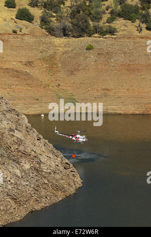 Mokassin, Kalifornien, USA. 4. September 2014. September 4, 2014.A Cal Fire Helicopter, fliegen weit unter Don Pedro Reservoir gewöhnlichen hohen Wasserstand, schöpft Wasser in dem Bemühen, das Jackson Feuer enthalten. Das Feuer befindet sich in der Nähe von Mokassin-Punkt in Tuolumne County, Kalifornien, und wurde angenommen, um ca. 11:30 am Donnerstag, 4. September 2014 begonnen haben. Turlock Irrigation District nutzt Wasser im Don Pedro ca. 5.800 Betriebe zu bewässern. Bildnachweis: Tracy Barbutes/ZUMA Draht/Alamy Live-Nachrichten Stockfoto