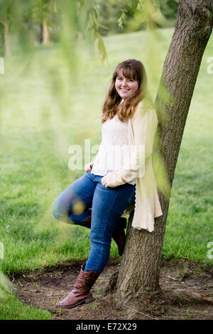 Porträt von Teenager-Mädchen (13-15) Baum gelehnt Stockfoto