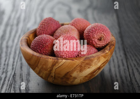 Reife Litschis in Holz Schüssel auf alten Eichentisch Stockfoto