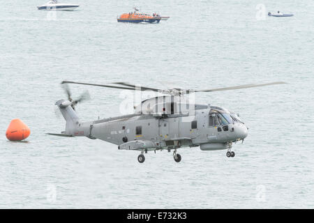 Eine königliche Marine Merlin HM1 Hubschrauber zeigt seine Fähigkeit, eine Winchman während der Bournemouth Air Festival 2014 zu senken. Stockfoto