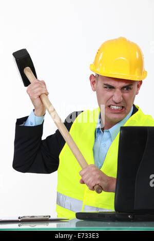 wütend Geschäftsmann seinen Laptop mit einem Hammer zerschlagen Stockfoto