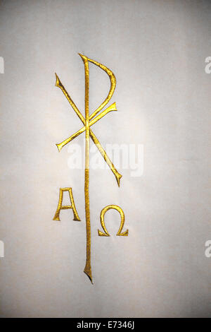 Religiöse Chi-Rho-Symbol mit Alpha Omega in Gold auf dem weißen Tuch bestickt Stockfoto