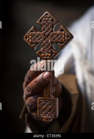 Priester hält ein Kreuz innen Yemrehana Krestos Felsenkirche, Lalibela, Äthiopien Stockfoto