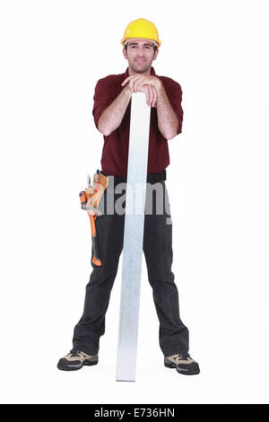 Porträt des jungen Schreiner posiert mit Hände ruhen auf Stahl plank Stockfoto