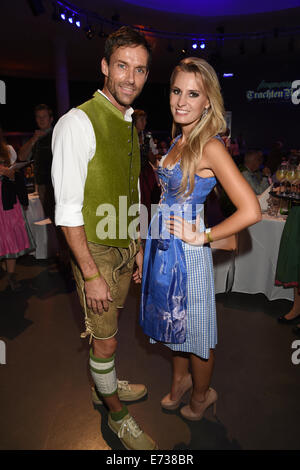 Ehemaliger Skispringer Sven Hannawald (L) stellt mit sogenannten Wiesnplaymate, Doreen Seidel, in der Tracht-Nacht im Postpalast in München, Deutschland, 4 Septmber 2014. Die traditionelle Kleidung Hersteller "Trachten Angermaier" präsentierte die neuesten Modetrends in traditioneller Kleidung im Vorfeld das "Oktoberfest" in München, die am 20. September 2014 beginnt. Foto: Felix Hoerhager/dpa Stockfoto