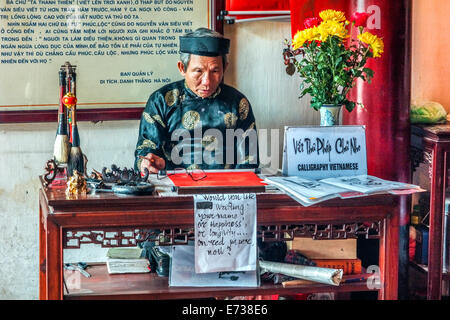 Alter Mann bietet Kalligraphie in Ngoc Son Tempel. Stockfoto