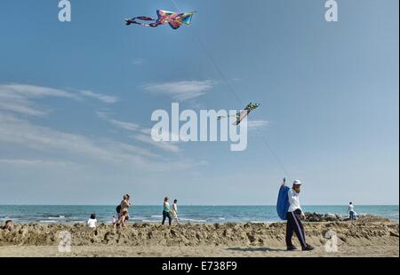 Caorle, Veneto, Italien. Mai 2014, Vorfrühling Seazon am Adria-Strand in Caorle Resort. Drachen-Verkäufer, ein Einwanderer fr Stockfoto