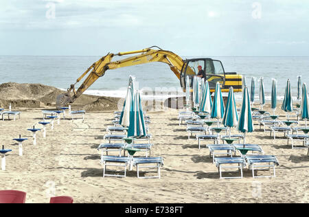 Caorle, Veneto, Italien. Mai 2014, Vorfrühling Seazon am Adria-Strand in Caorle Resort. Arbeiter Reinigung Strand neben Stockfoto