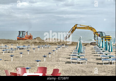 Caorle, Veneto, Italien. Mai 2014, Vorfrühling Seazon am Adria-Strand in Caorle Resort. Arbeiter Reinigung Strand neben Stockfoto