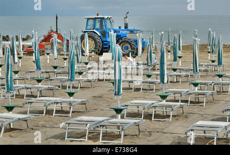 Caorle, Veneto, Italien. Mai 2014, Vorfrühling Seazon am Adria-Strand in Caorle Resort. Arbeiter Reinigung Strand neben Stockfoto