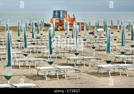 Caorle, Veneto, Italien. Mai 2014, Vorfrühling Seazon am Adria-Strand in Caorle Resort. Arbeiter Reinigung Strand neben Stockfoto