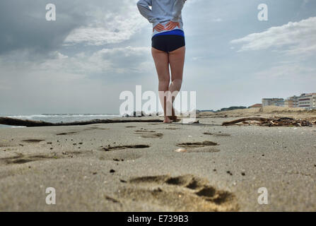 Caorle, Veneto, Italien. Mai 2014, Vorfrühling Seazon am Adria-Strand in Caorle Resort. Junge Frau geht auf die beac Stockfoto