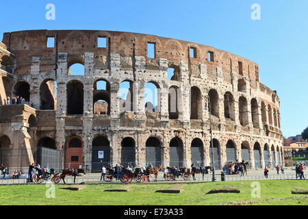 Besucher und Kutschen neben der Außenwand des Kolosseums, Forum, Rome, Lazio, Italien, Europa Stockfoto