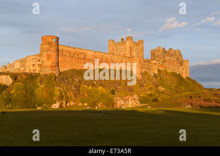 Bamburgh Castle und Cricket Green in Abendsonne, Bamburgh, Northumberland, England, Vereinigtes Königreich, Europa Stockfoto