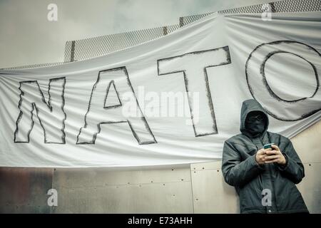 Newport, Wales, UK. 4. September 2014. Ein Demonstrant gegen den NATO-Gipfel lehnt sich an eine Stahl Barriere von der Polizei während einer Demonstration installiert. © Matthias Oesterle/ZUMA Wire/ZUMAPRESS.com/Alamy Live-Nachrichten Stockfoto