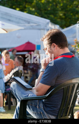 Ein Besucher liest ein e-Book am Eröffnungstag des Edinburgh International Book Festival 2014. Edinburgh, Schottland. 9. August Stockfoto