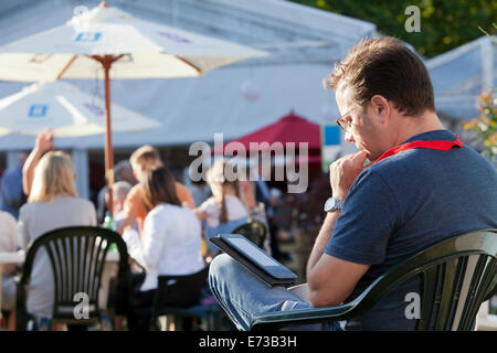 Ein Besucher liest ein e-Book am Eröffnungstag des Edinburgh International Book Festival 2014. Edinburgh, Schottland. Stockfoto