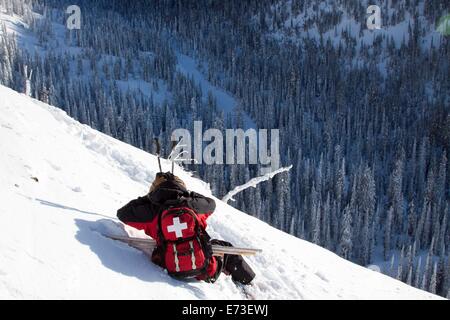 Ski Patroller deckt ihre Ohren. Stockfoto