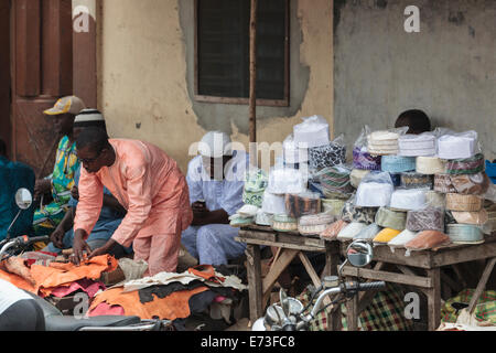 Afrika, Benin, Cotonou. Männer Kufi Hüte in traditioneller Wochenmarkt zu verkaufen. Stockfoto