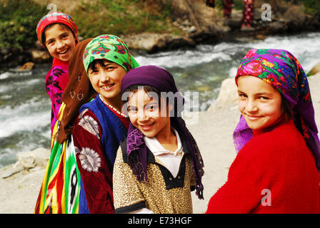 Tadschikistan, Penjakent, Gruppe von Mädchen in Tracht am Fluss. Stockfoto