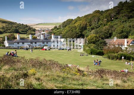 Urlauber auf dem Dorfplatz umgeben von weißen Cottages, Kneipen und Souvenirläden bei Lulworth Cove Dorset, UK Stockfoto