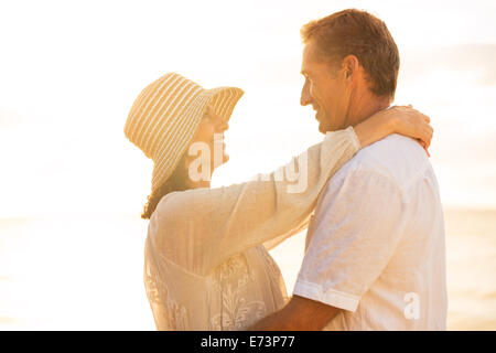 Glücklich romantische älteres Paar in Liebe am Strand bei Sonnenuntergang Stockfoto