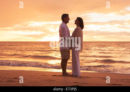 Romantische applying paar in Liebe umarmen am Strand bei Sonnenuntergang Stockfoto