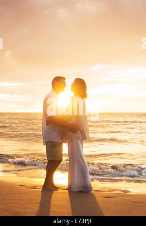 Romantische älteres Paar küssen bei Sonnenuntergang am Strand Stockfoto