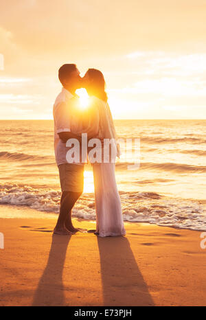 Romantische älteres Paar küssen bei Sonnenuntergang am Strand Stockfoto